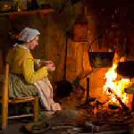 Colonial woman at fireplace